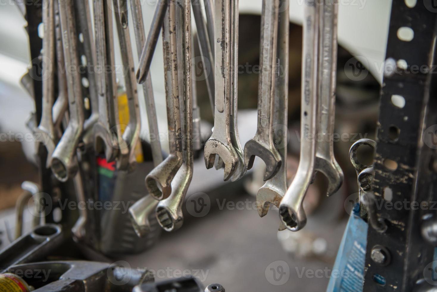 set sporco di chiavi metalliche e strumenti di varie dimensioni in garage foto