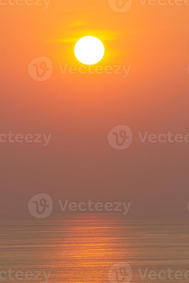 tramonto, la superficie del mare, che riflette il sole in arancione. cielo sereno, arancione senza nuvole foto