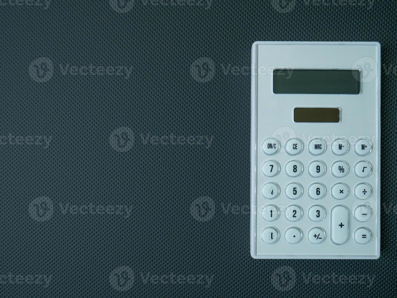 la calcolatrice bianca su sfondo nero per i contenuti aziendali. foto