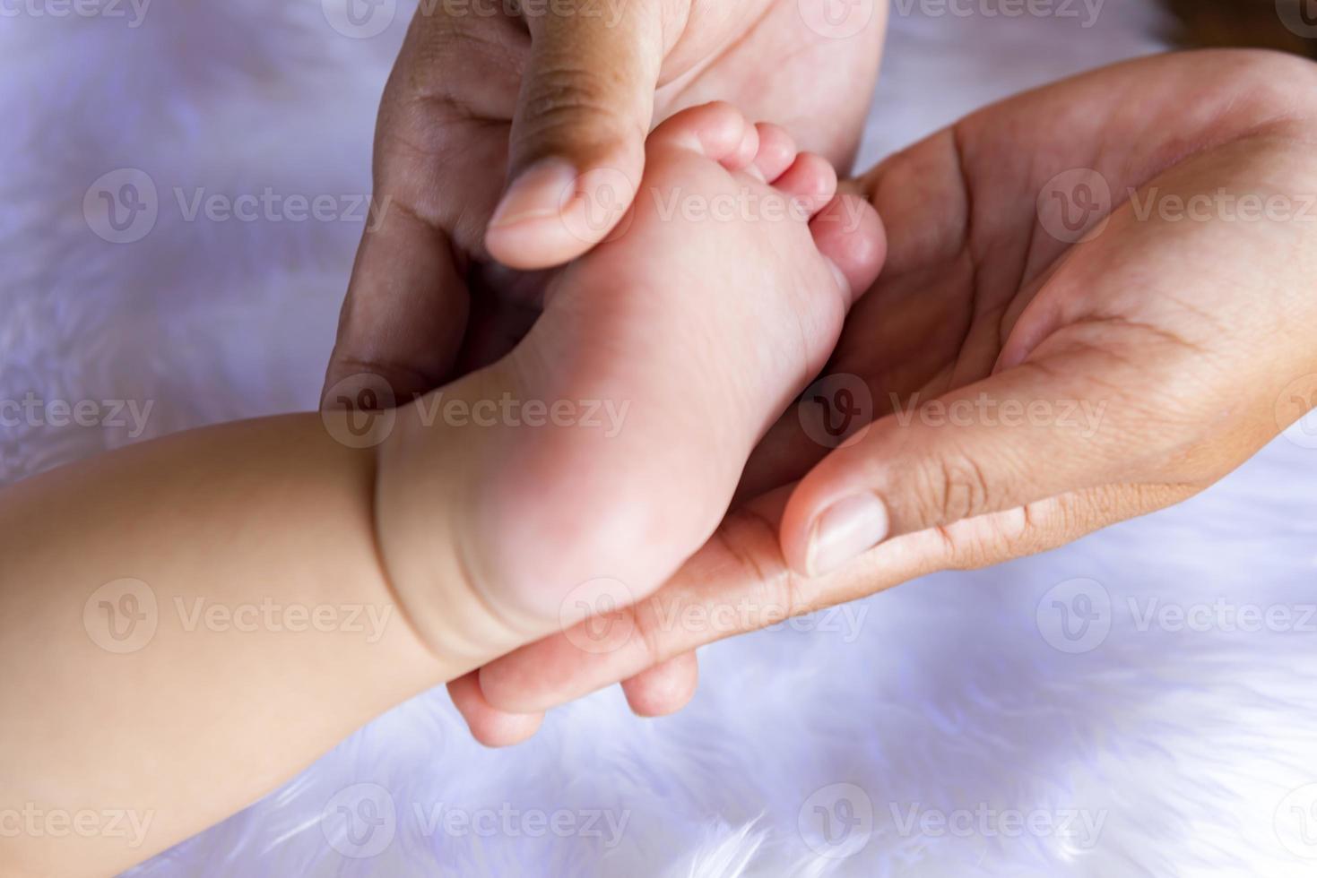 piedi del bambino nelle mani del padre. minuscole gambe di un neonato su mani maschili, primo piano. il concetto di una famiglia felice. la festa del papà foto