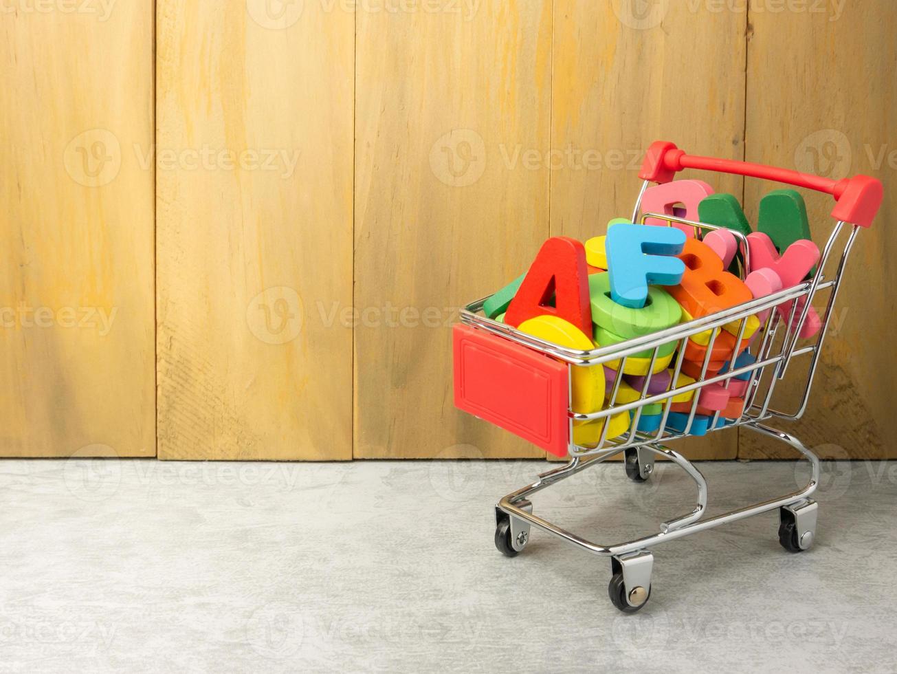 l'alfabeto multicolore nel carrello per l'istruzione o il concetto di marketing foto