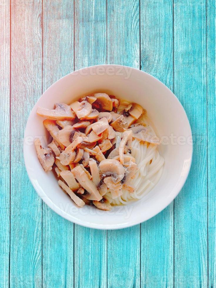 funghi con tagliatelle. bagliore del sole. tavolo di legno. foto