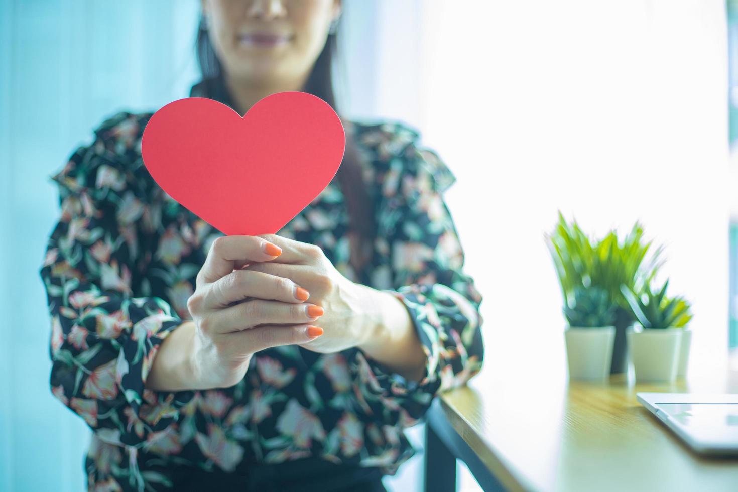 donna che tiene cuore rosso assicurazione sanitaria donazione felice carità volontario concetto giornata mondiale del cuore speranza gratitudine riconoscente fiducia pregando complimento giorno foto