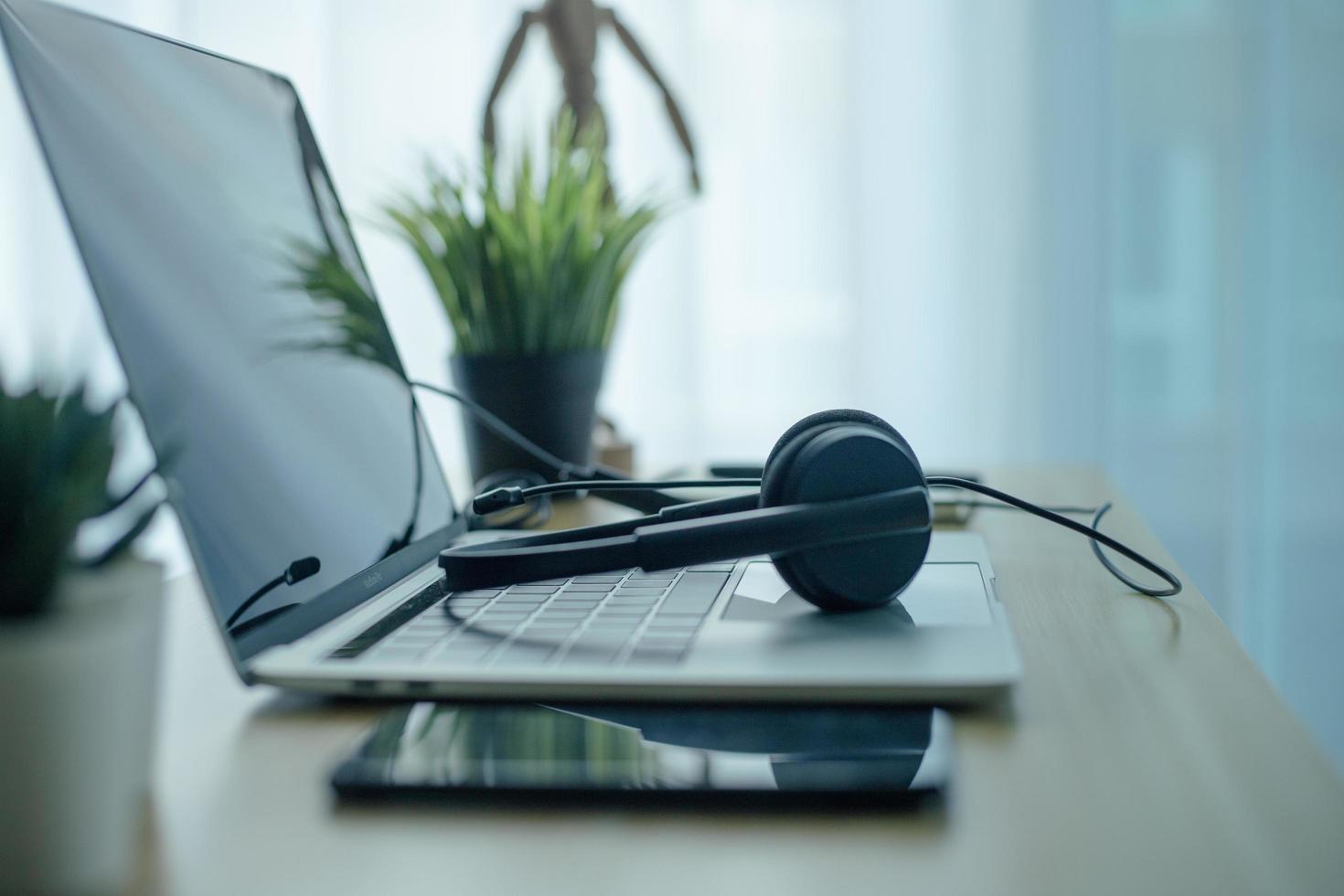 cuffie cuffie telefono e laptop nel call center dell'home office foto