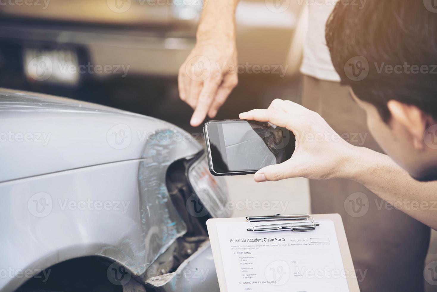 agente assicurativo che lavora durante il processo di richiesta di risarcimento per incidente stradale in loco - concetto di richiesta di risarcimento per le persone e l'assicurazione auto foto