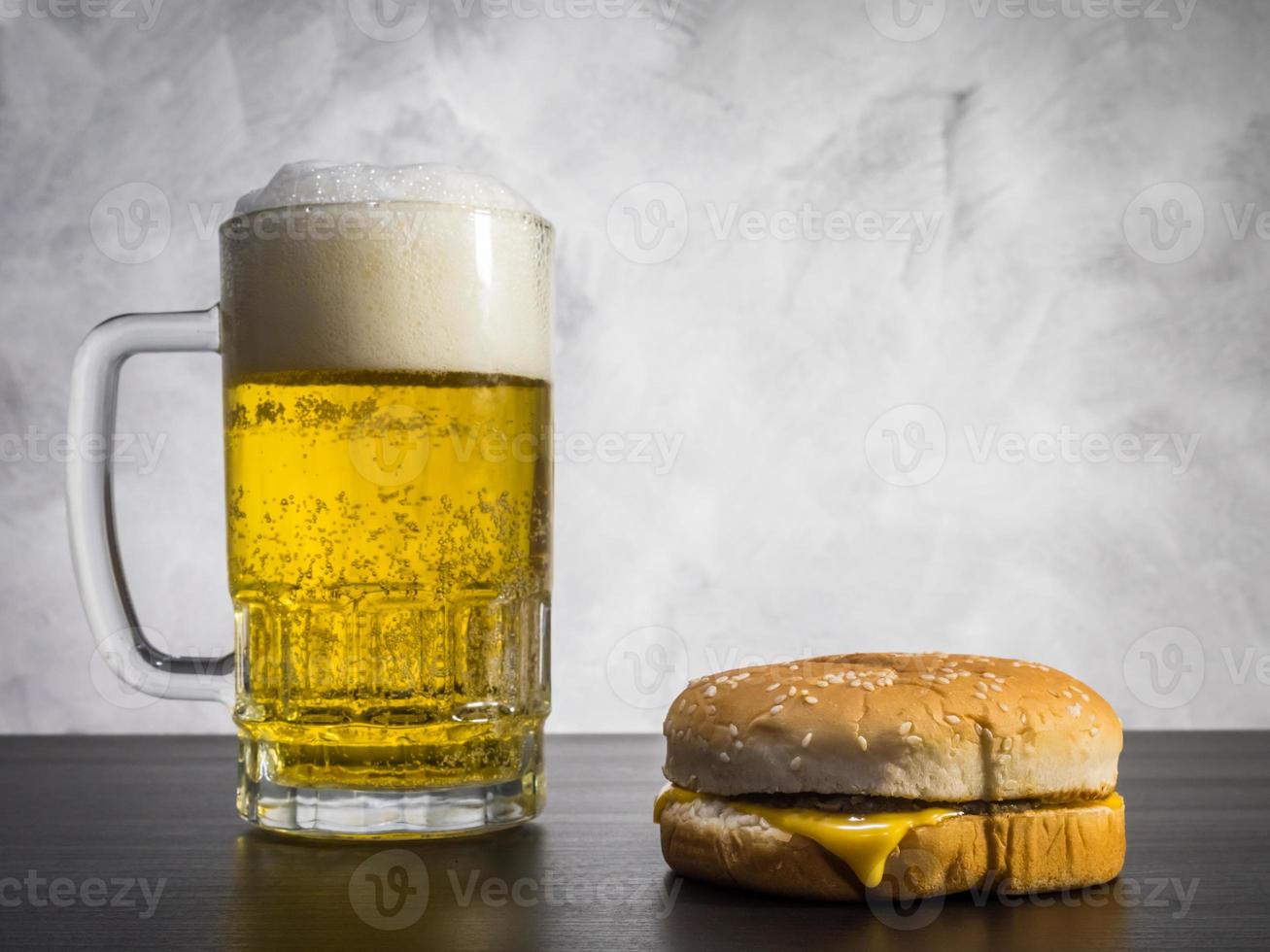 hamburger con bicchiere di birra sul tavolo su uno sfondo grunge. foto
