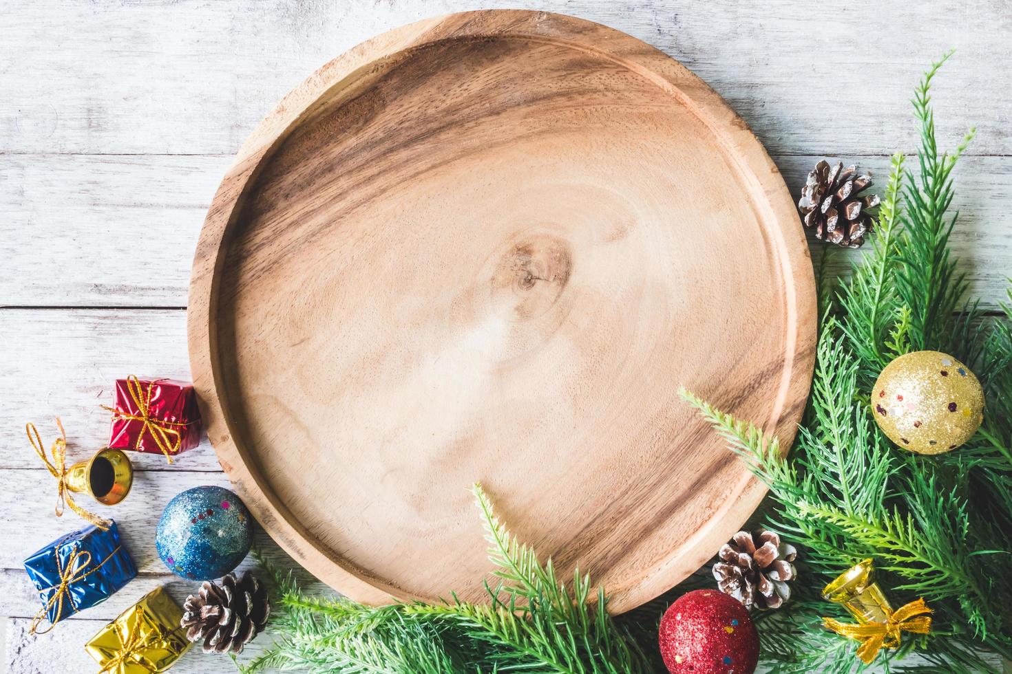 vista dall'alto del piatto di legno con decorazioni natalizie su sfondo tavolo in legno foto