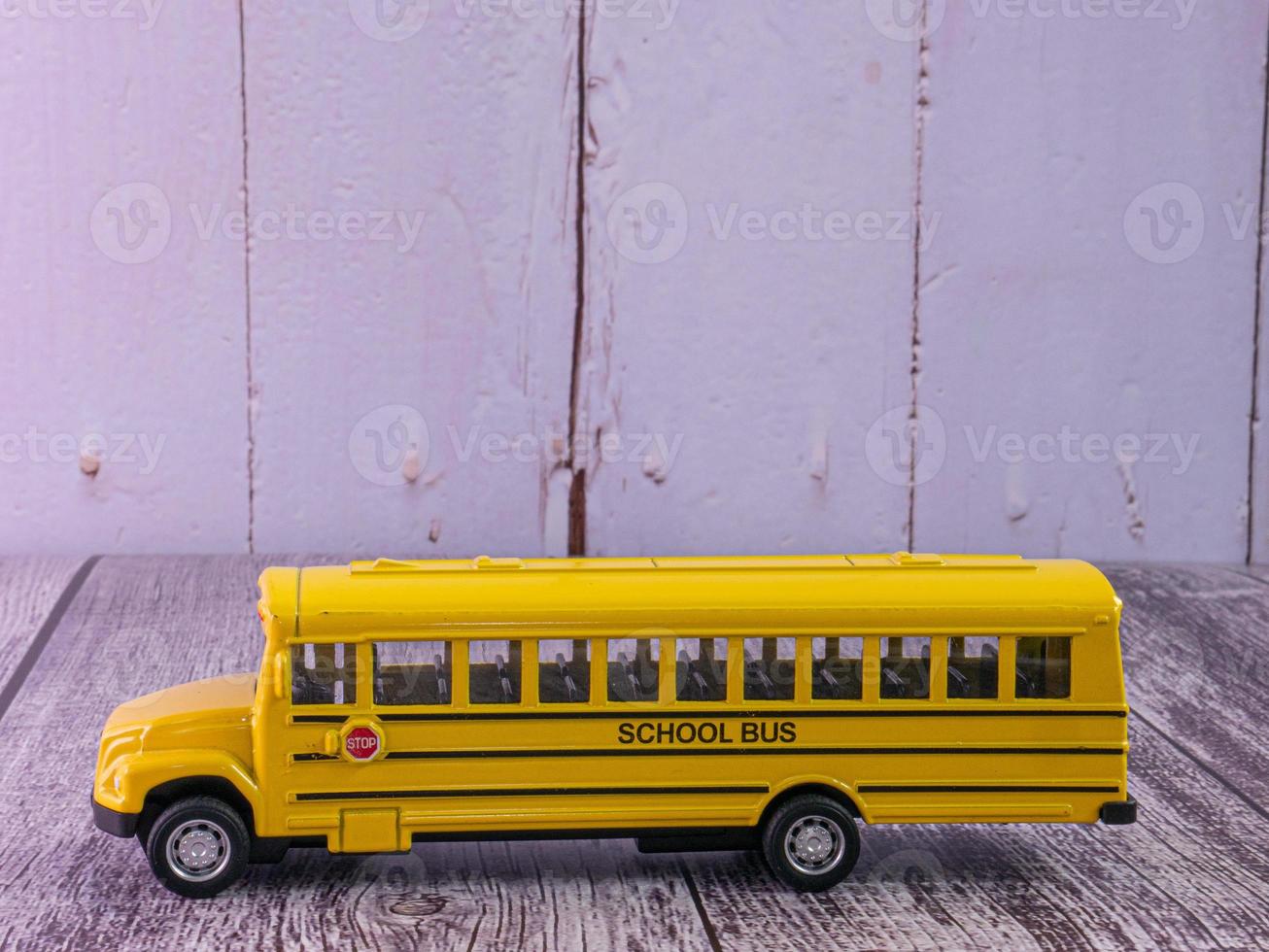 scuolabus sul tavolo di legno per il concetto di istruzione foto