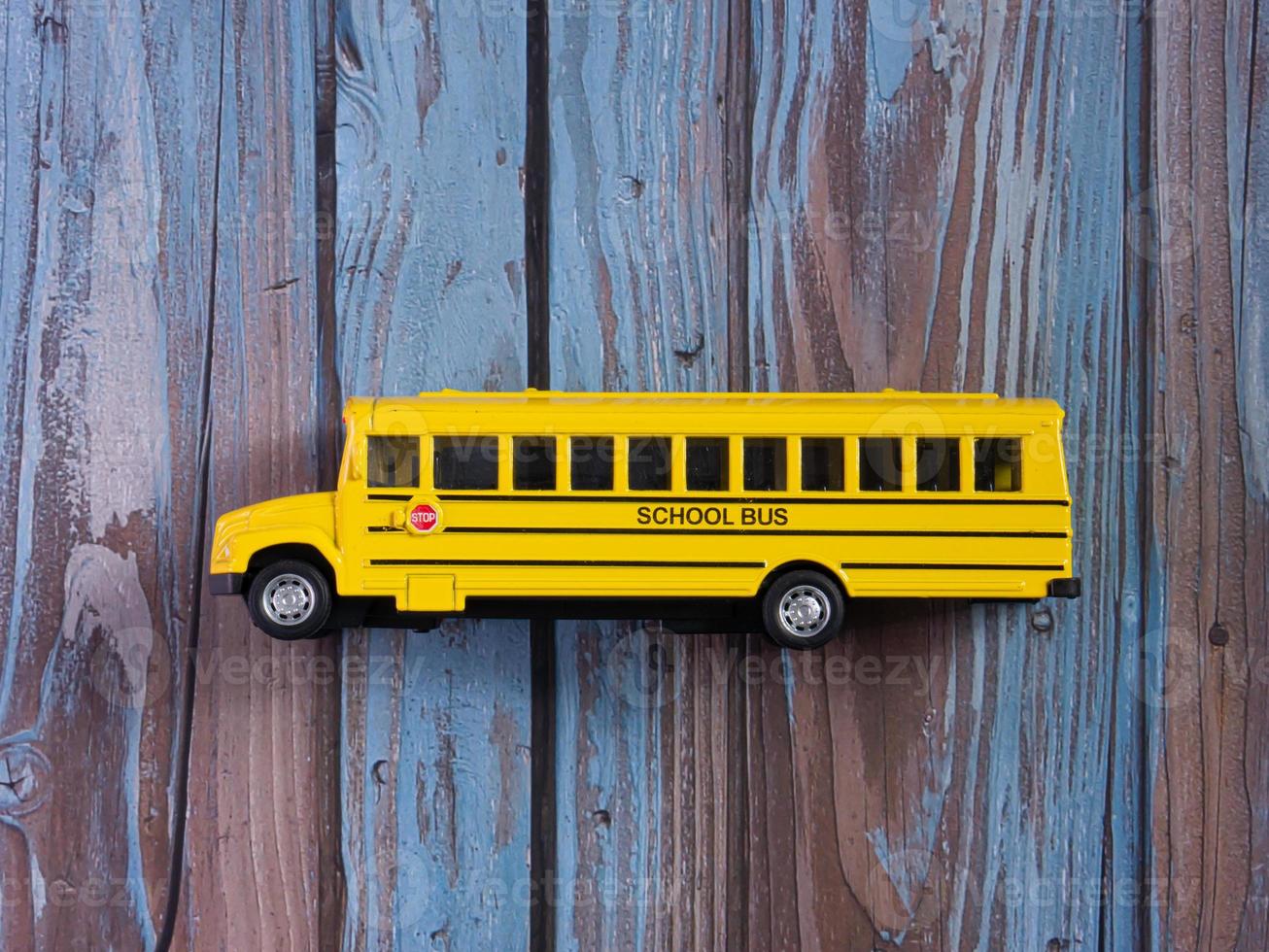 scuolabus sul tavolo di legno per l'istruzione o il concetto di trasporto foto