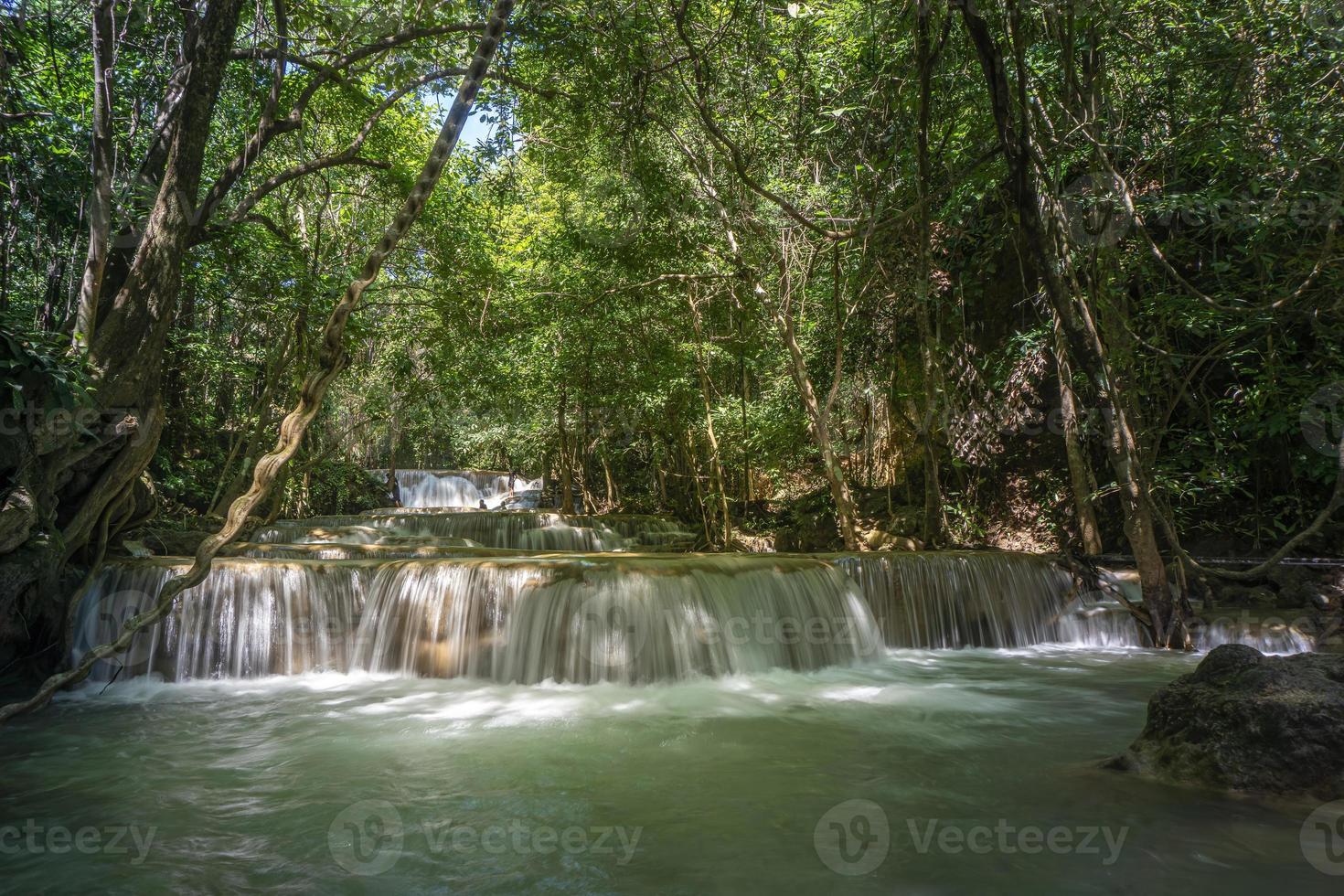 nella limpida cascata c'è un colore verde smeraldo causato dai riflessi di alberi e licheni che circolano attraverso il calcare giallo. cascata di huai mae khamin, provincia di kanchanaburi foto