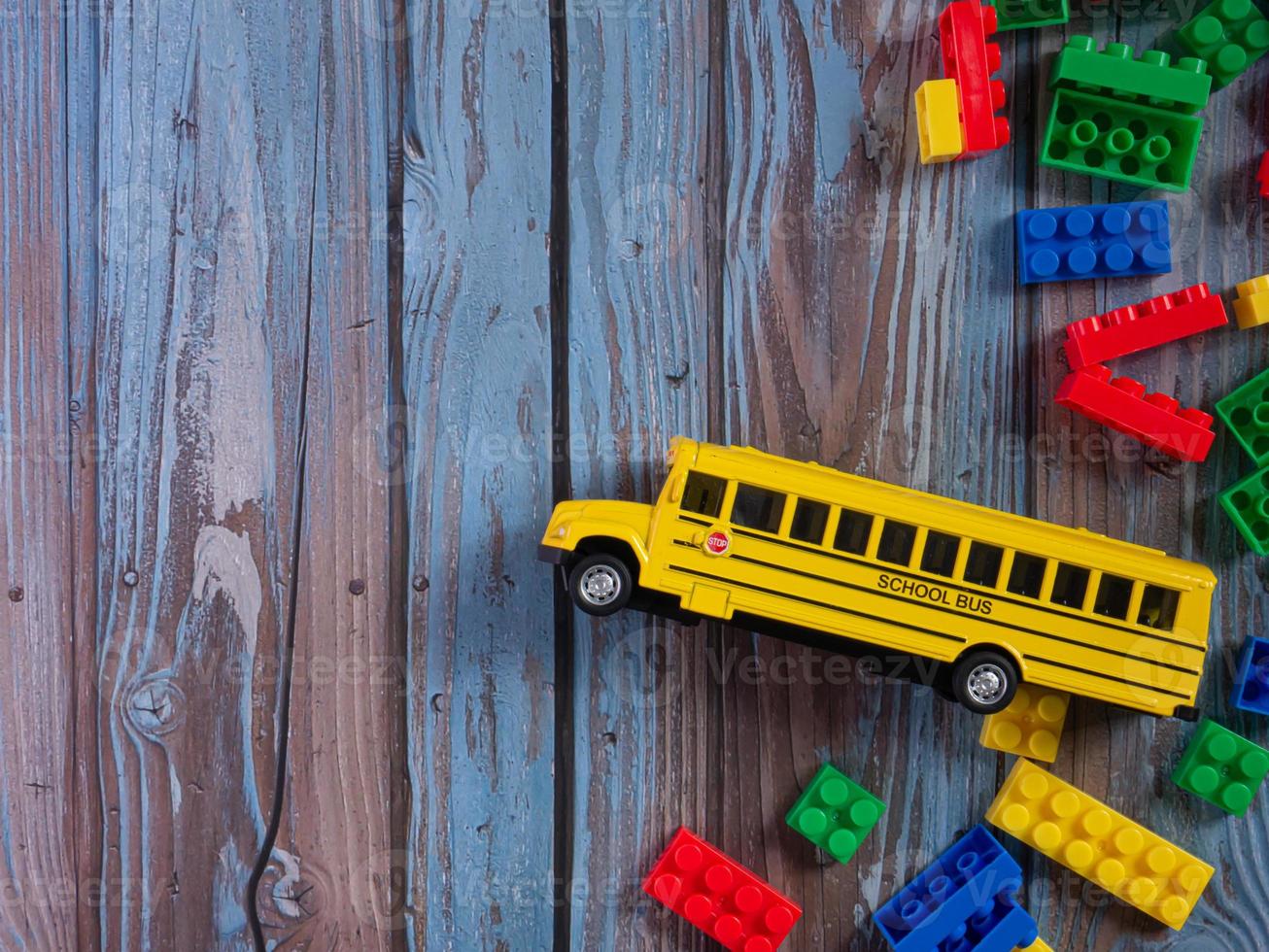 scuolabus sul tavolo di legno per l'istruzione o il concetto di trasporto foto