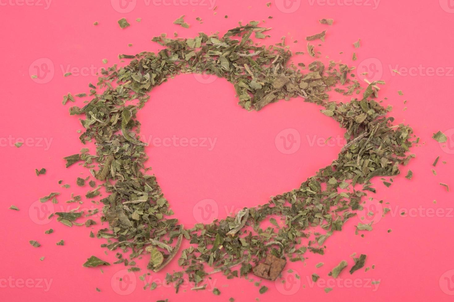 forma di cuore di marijuana schiacciata su sfondo rosa San Valentino per gli amanti della cannabis foto