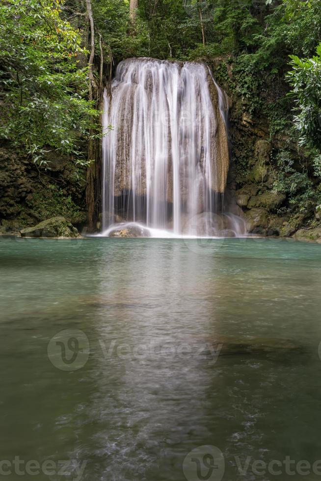 acqua verde smeraldo pulita dalla cascata circondata da piccoli alberi - grandi alberi, colore verde, cascata di erawan, provincia di kanchanaburi, tailandia foto