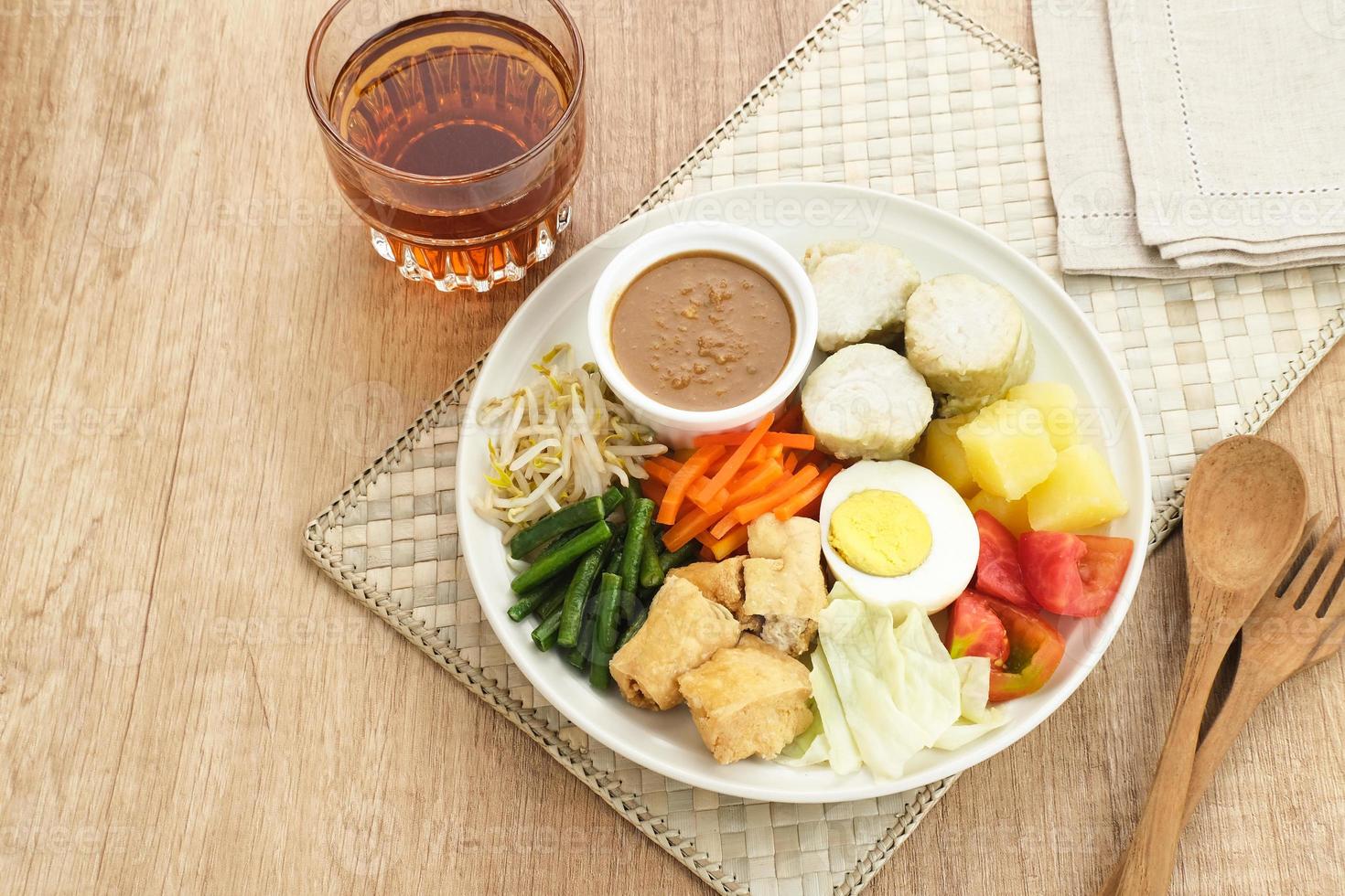 gado gado, insalata di verdure tradizionale indonesiana con salsa di arachidi, torta di riso, tofu e uova foto