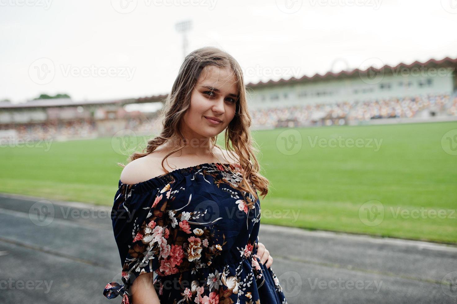 ritratto di una favolosa ragazza in abito e tacchi alti in pista allo stadio. foto