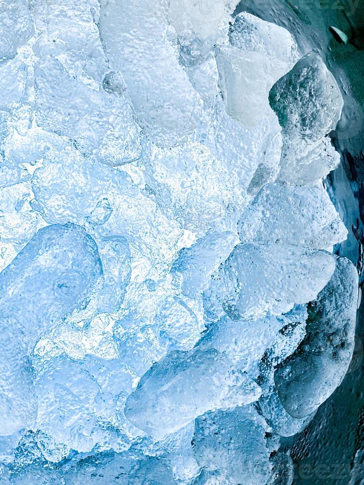 sfondo astratto di ghiaccio, i cubetti di ghiaccio si sentono freschi nelle giornate calde, il ghiaccio è indispensabile in estate. ti aiuterà a rinfrescarti e a farti sentire bene. foto