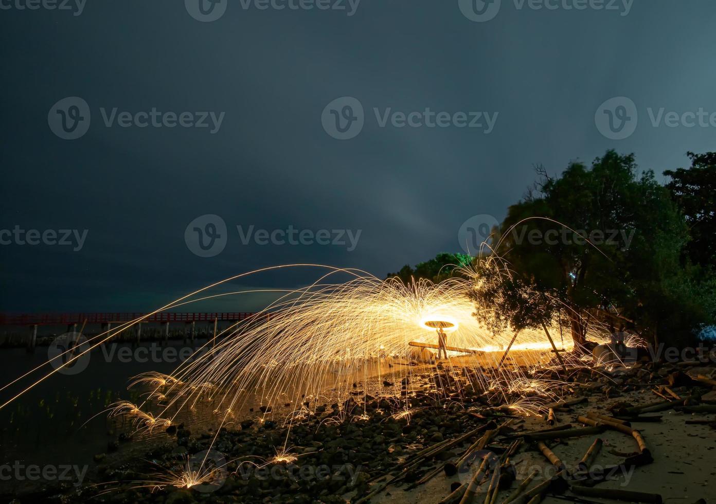 giocando con le fiamme tenendo un fuoco per provocare fiocchi foto