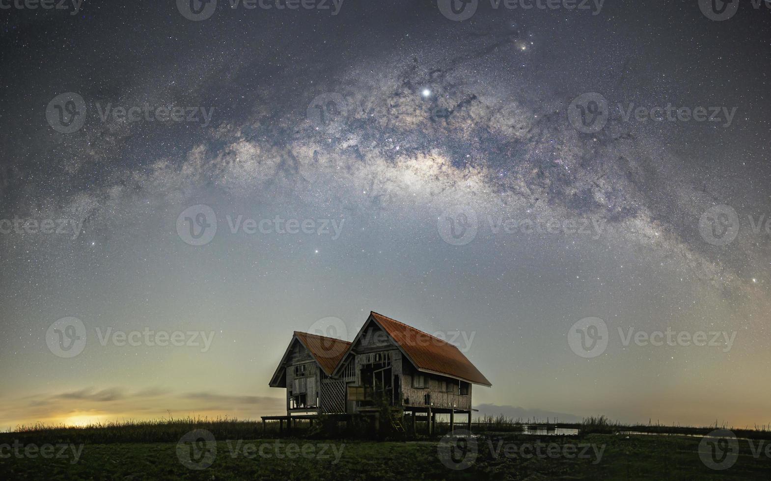 panorama della via lattea, vecchia casa abbandonata, tetto rosso in campo aperto foto