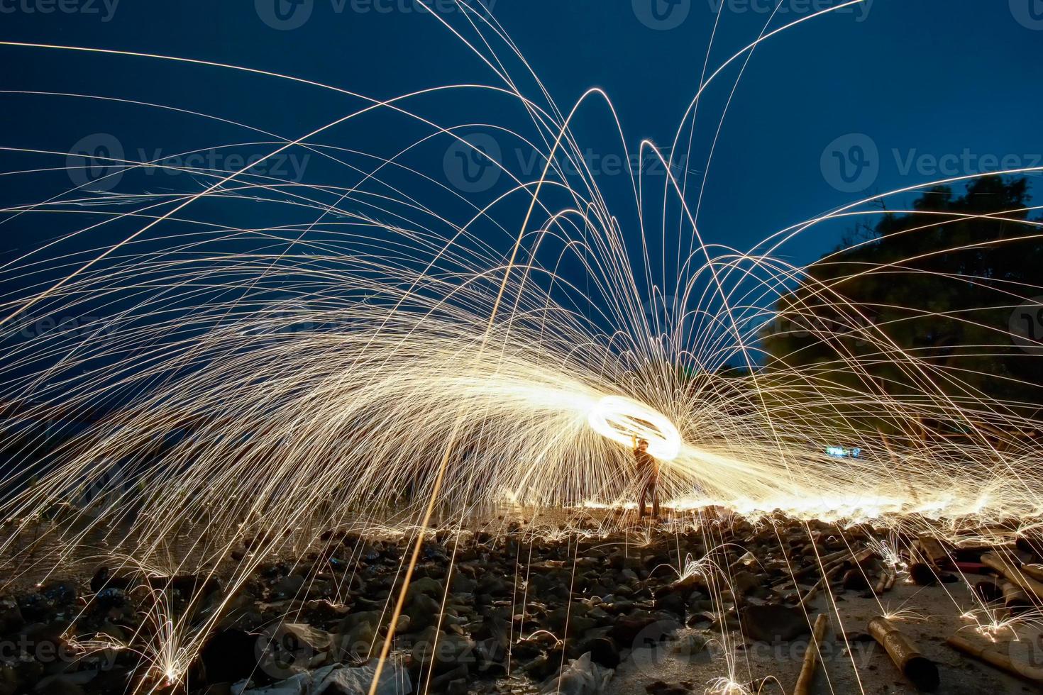 giocando con le fiamme tenendo un fuoco per provocare fiocchi foto