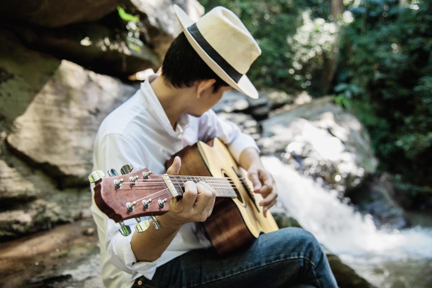 l'uomo suona l'ukulele nuovo alla cascata - persone e strumenti musicali stile di vita nel concetto di natura foto