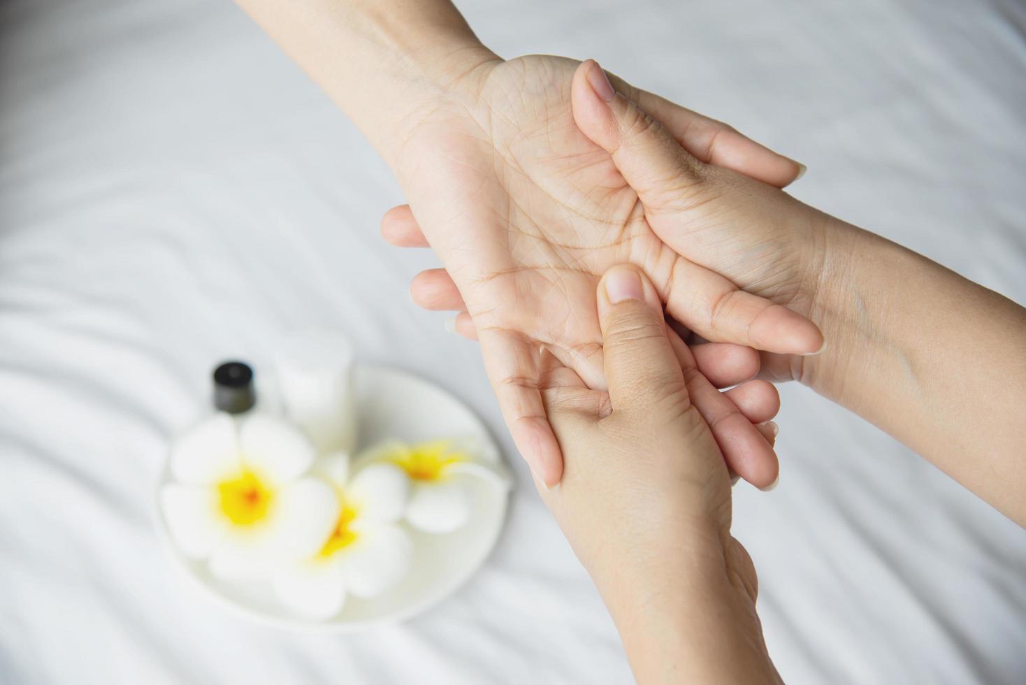 massaggio termale a mano su sfondo bianco pulito - le persone si rilassano con il servizio di massaggio alle mani foto