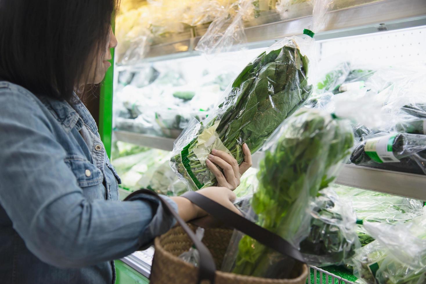 la signora sta acquistando verdura fresca nel negozio del supermercato - donna nel concetto di stile di vita del mercato fresco foto