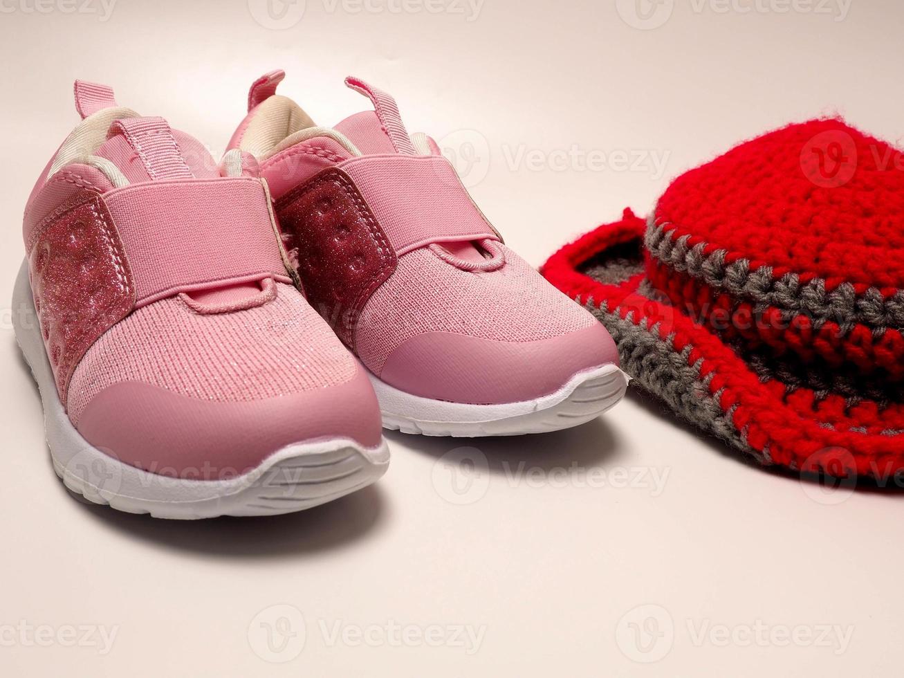 foto di colore rosso con cappello all'uncinetto a righe grigie e un paio di scarpe rosa