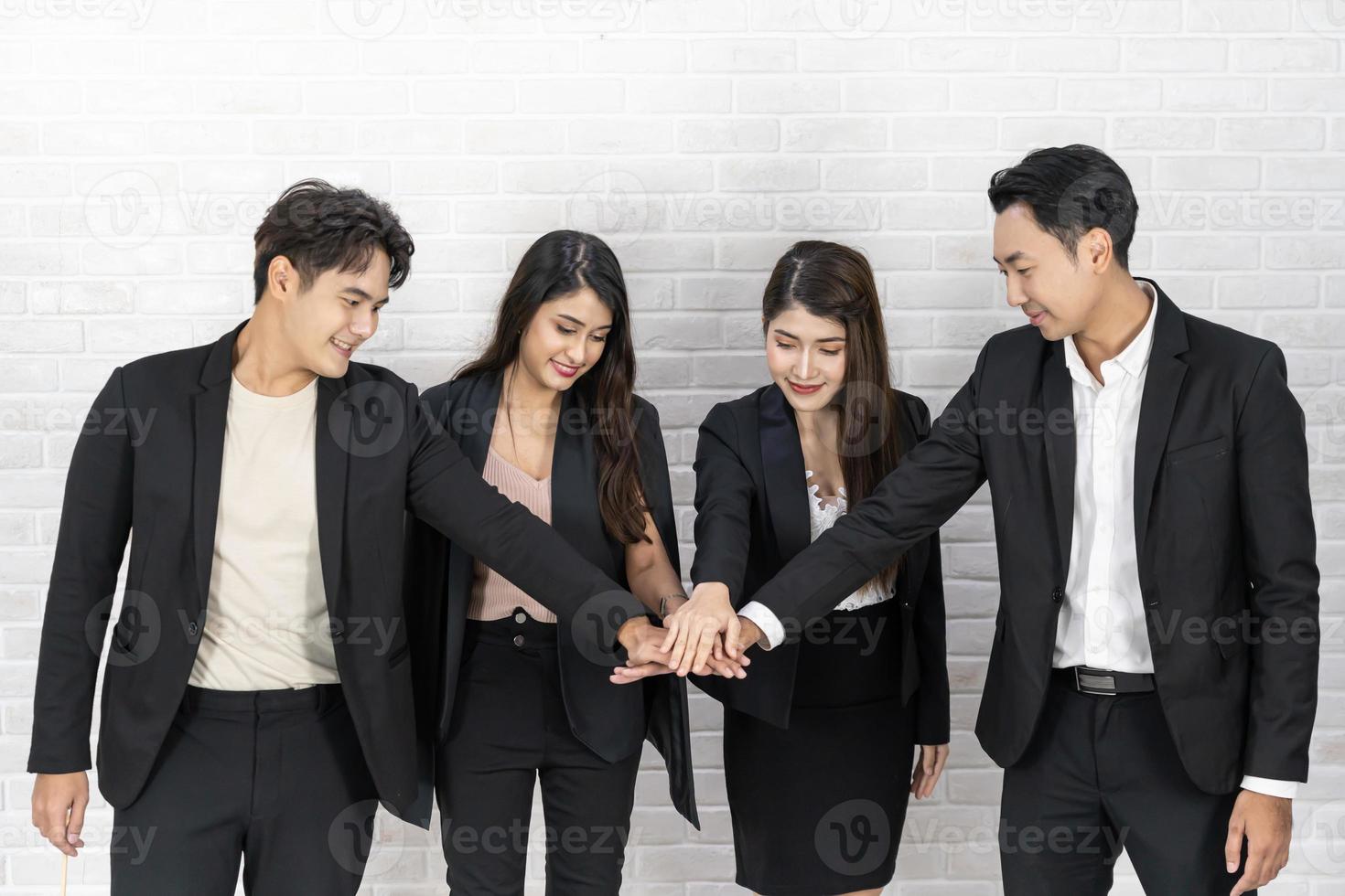 lavoro di squadra amicizia gruppo brainstorming insieme. diversità business partner persone lavoro di squadra tenendosi per mano potere del tag team. colleghi sorridenti felici con le targhette che impilano le mani. foto