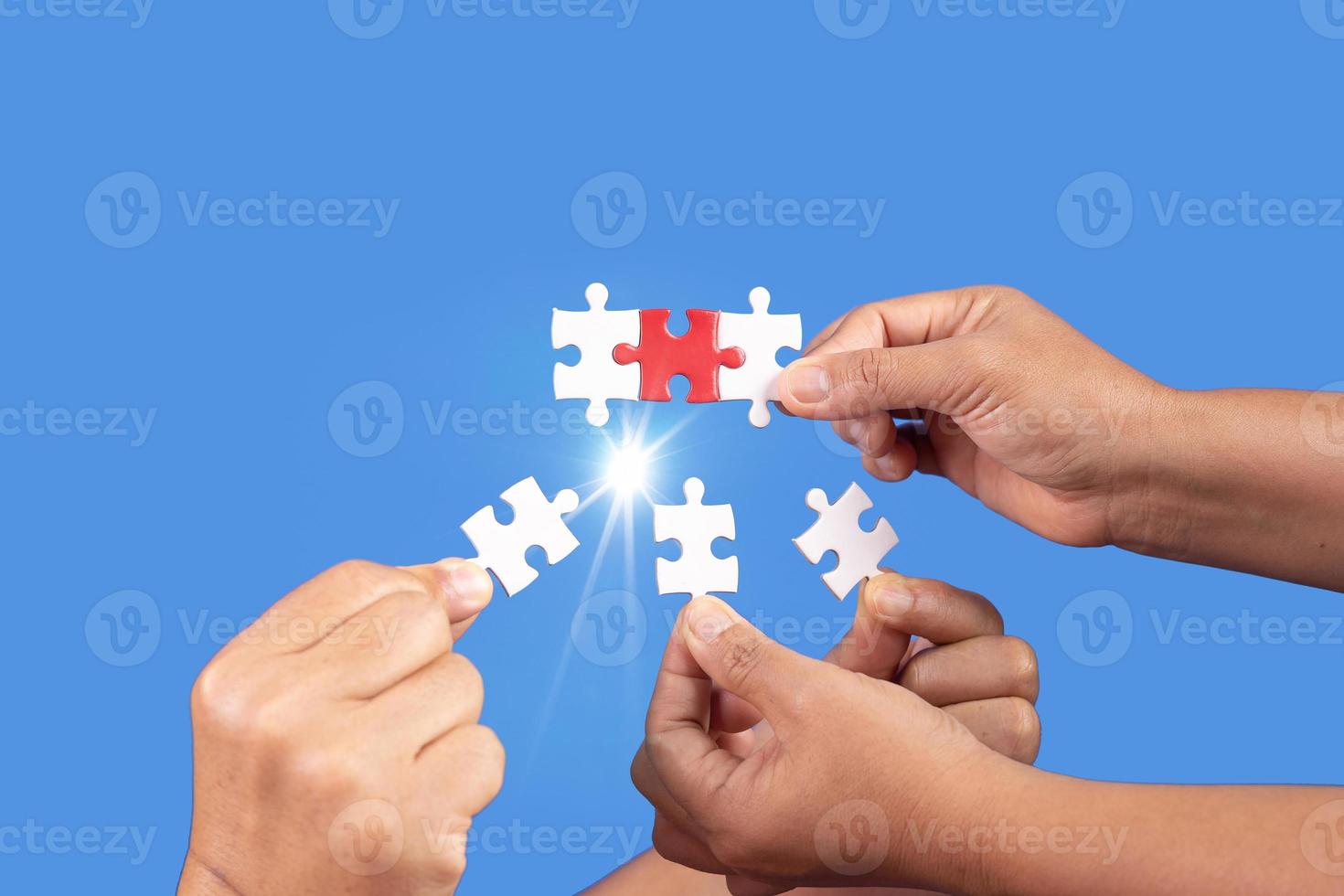 mani che tengono un pezzo di puzzle con sfondo blu chiaro, affari di successo, strategia di soluzione, concetto di partnership di lavoro di squadra foto