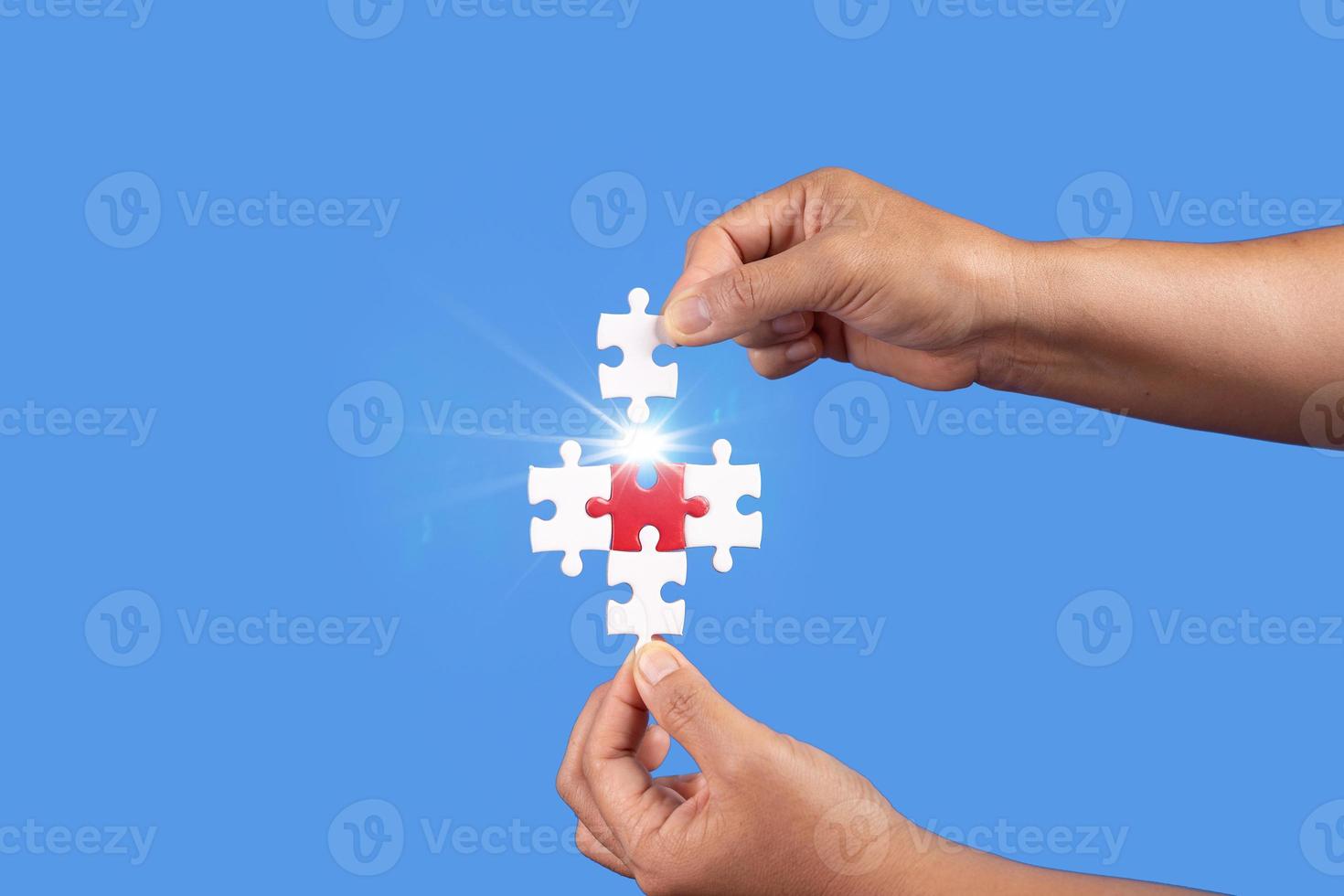 mani che tengono un pezzo di puzzle con sfondo blu chiaro, affari di successo, strategia di soluzione, concetto di partnership di lavoro di squadra foto