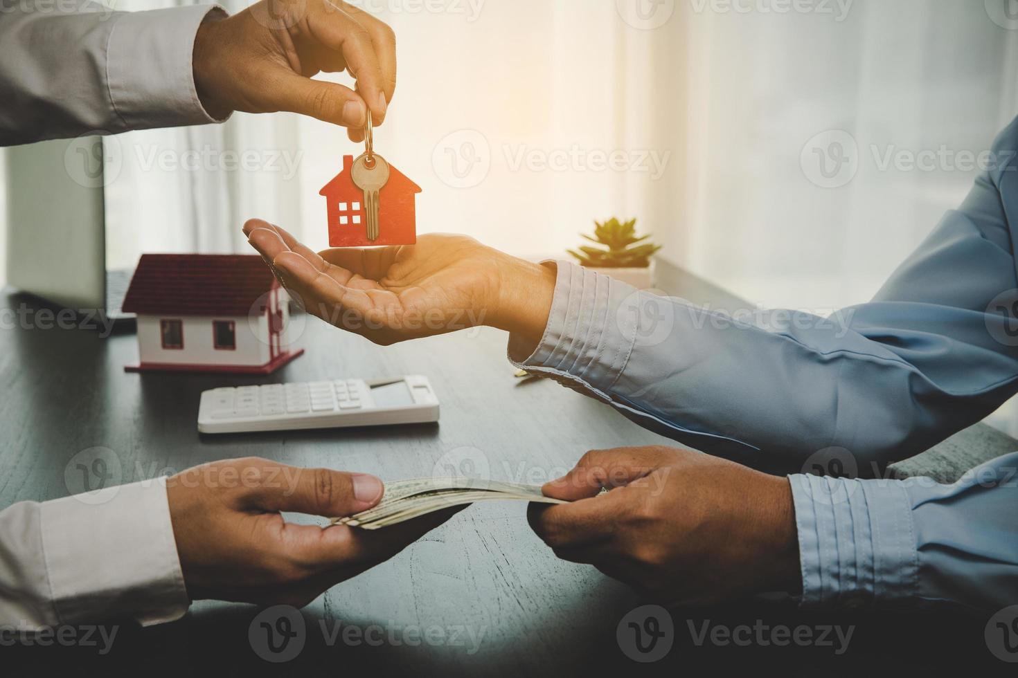agente immobiliare che tiene la chiave di casa al suo cliente dopo aver firmato il contratto, il concetto di prestito aziendale, mutuo di investimento, immobiliare, trasloco o affitto di proprietà. foto