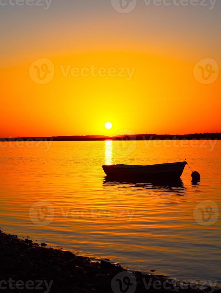 barca in mare con bel tramonto foto