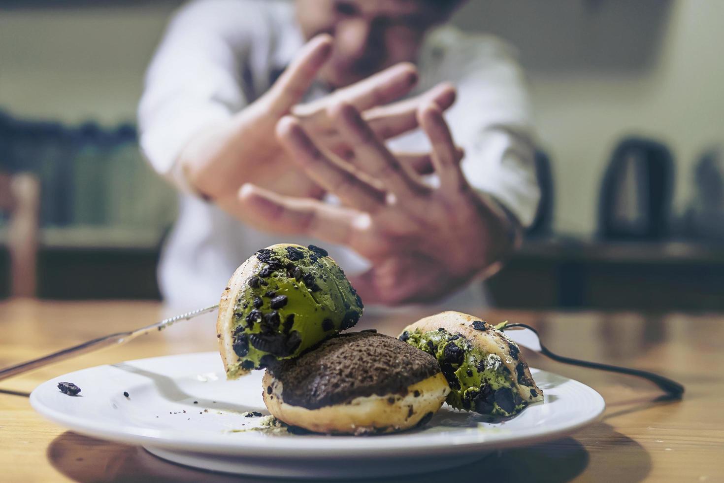 ragazzo non è d'accordo a mangiare la ciambella foto