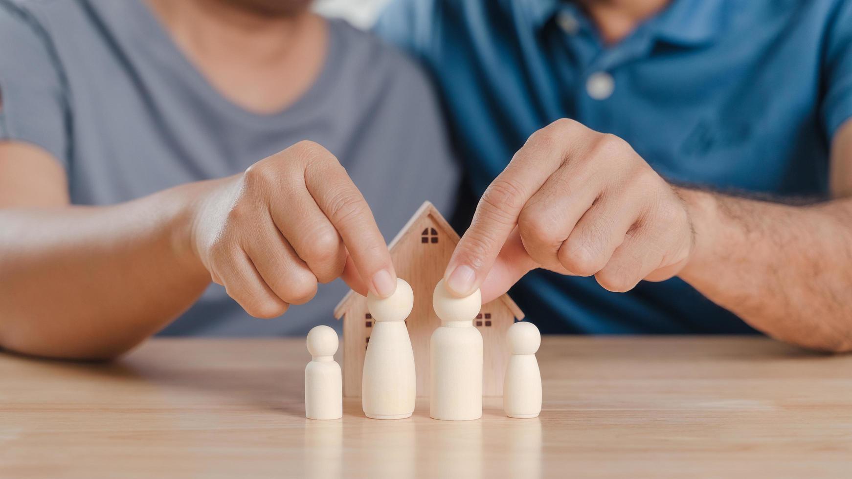 famiglia di bambole in legno, con coppia uomo e donna. pianificazione, salvataggio della famiglia, assistenza sanitaria e assicurazioni, salute mentale della famiglia, giornata internazionale delle famiglie foto