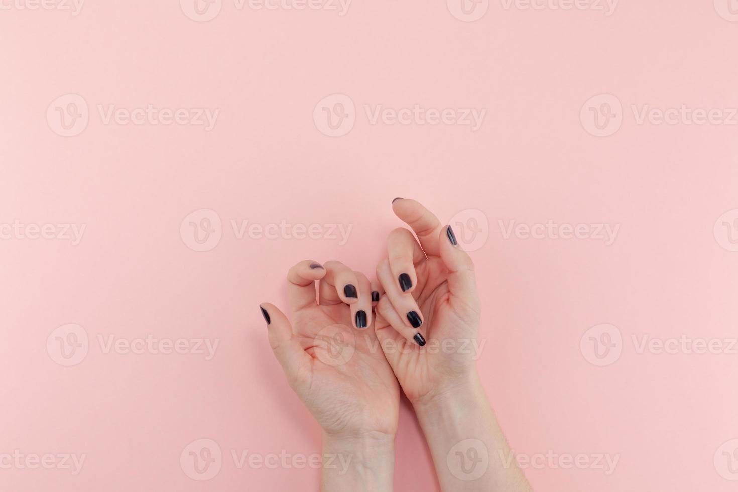 mani di donna con manicure nera foto