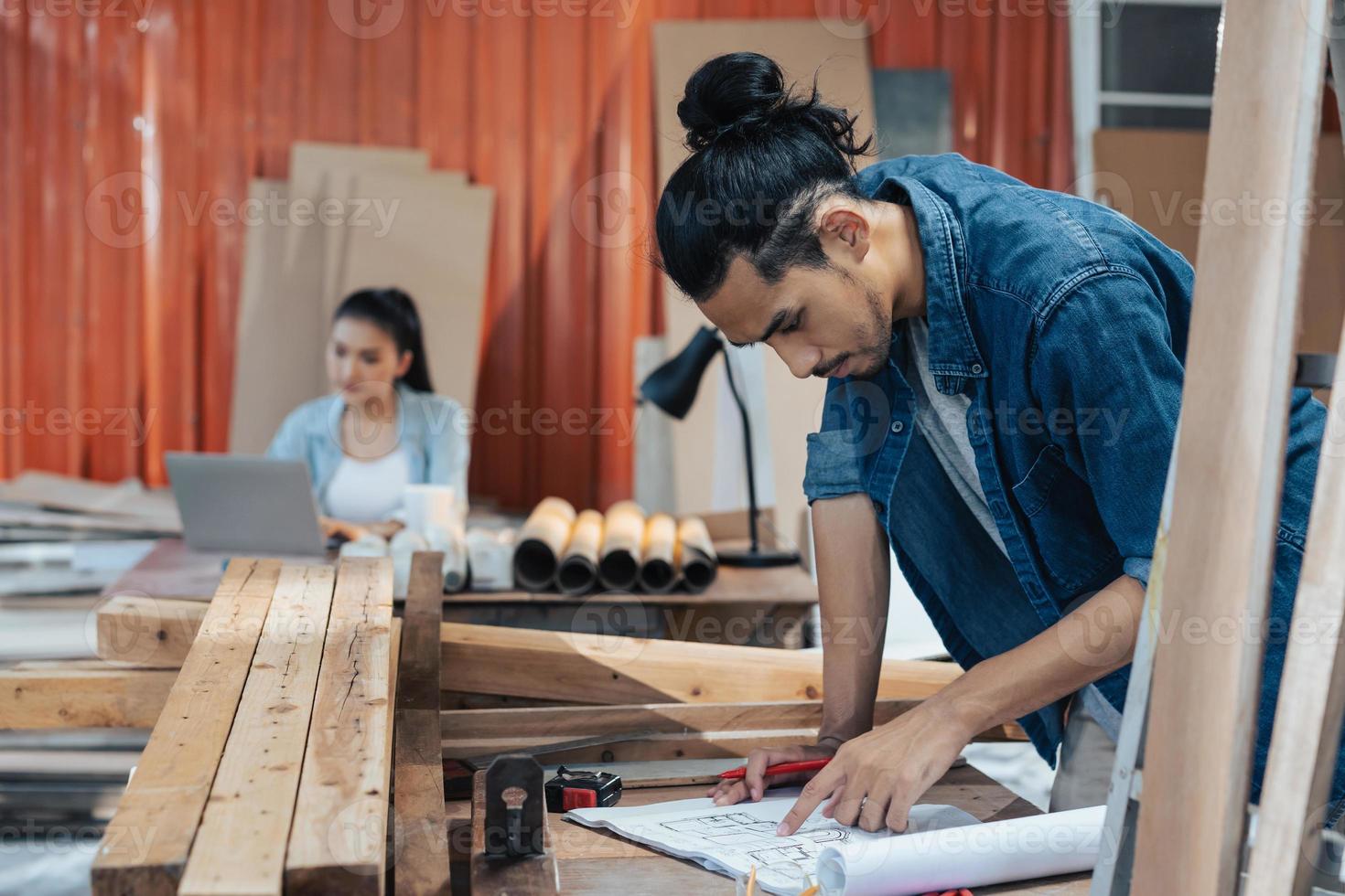 giovane falegname asiatico che lavora nel laboratorio di falegnameria di woodcraft. foto