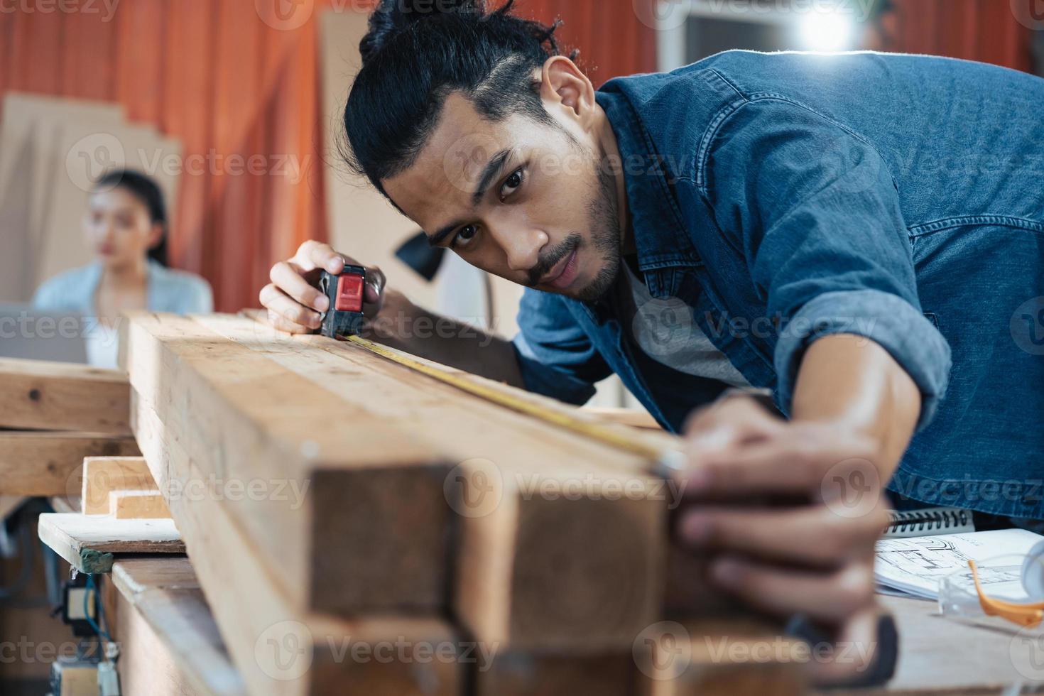 giovane falegname asiatico che lavora nel laboratorio di falegnameria di woodcraft. foto