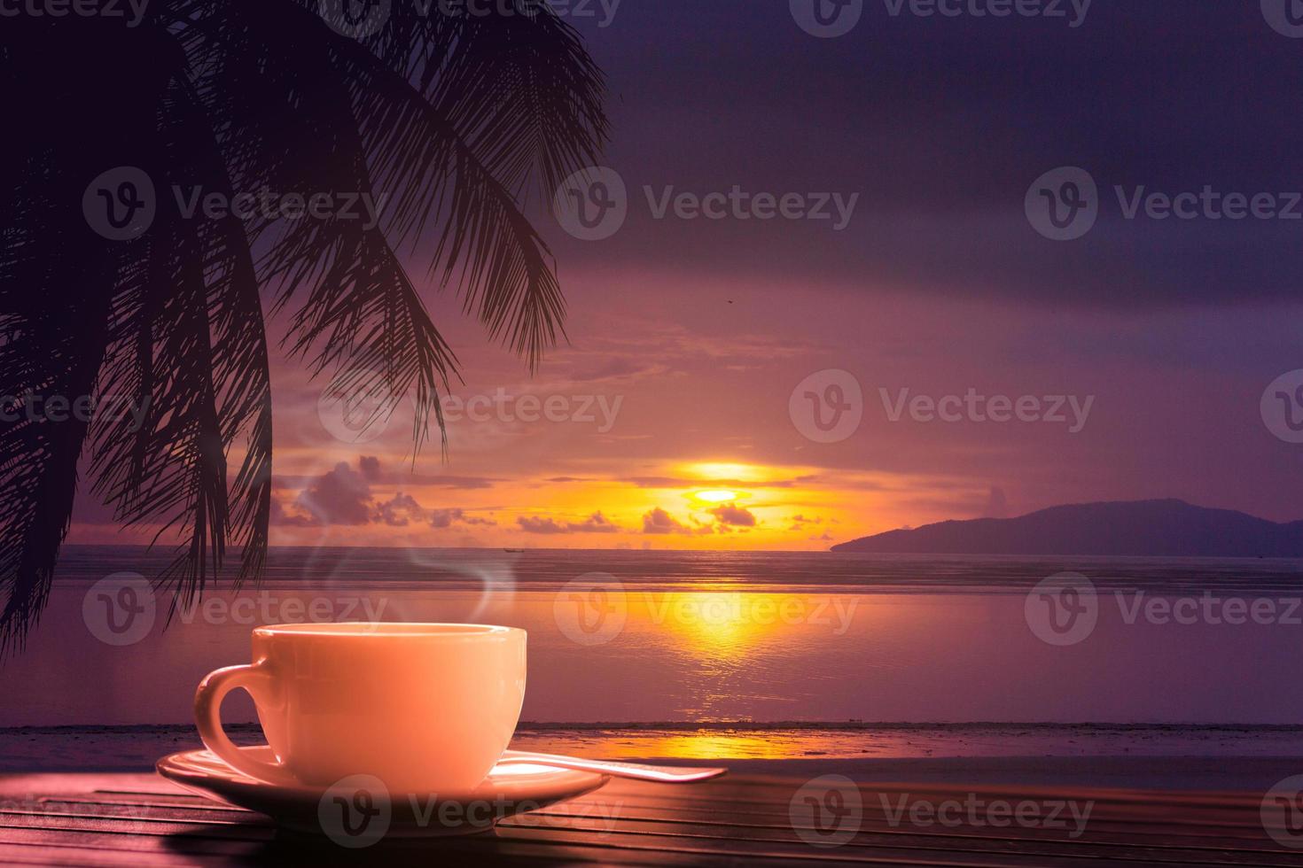 caffè caldo sul fondo del tramonto del mare della tavola di legno foto