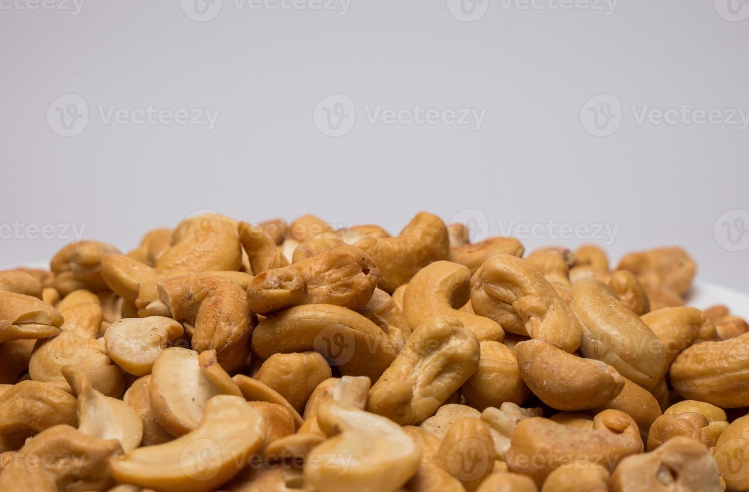 anacardi intero su sfondo bianco. spuntino vegetariano sano. foto ravvicinata. spazio per il tuo testo.