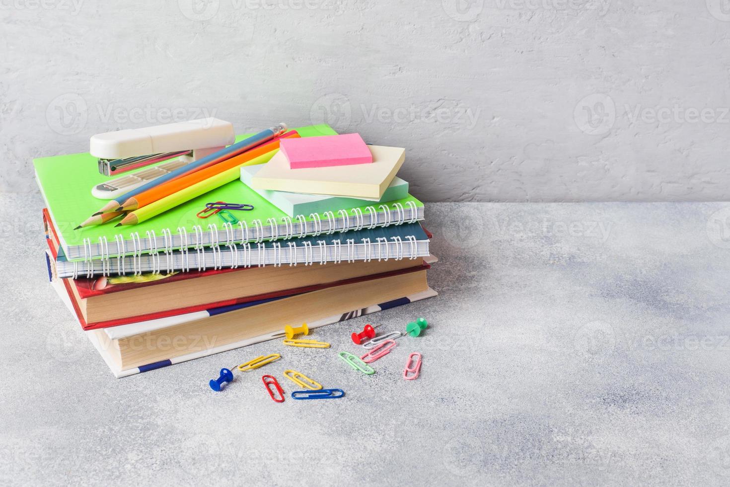 materiale scolastico, libri, quaderni, matite su sfondo grigio con spazio per la copia. foto