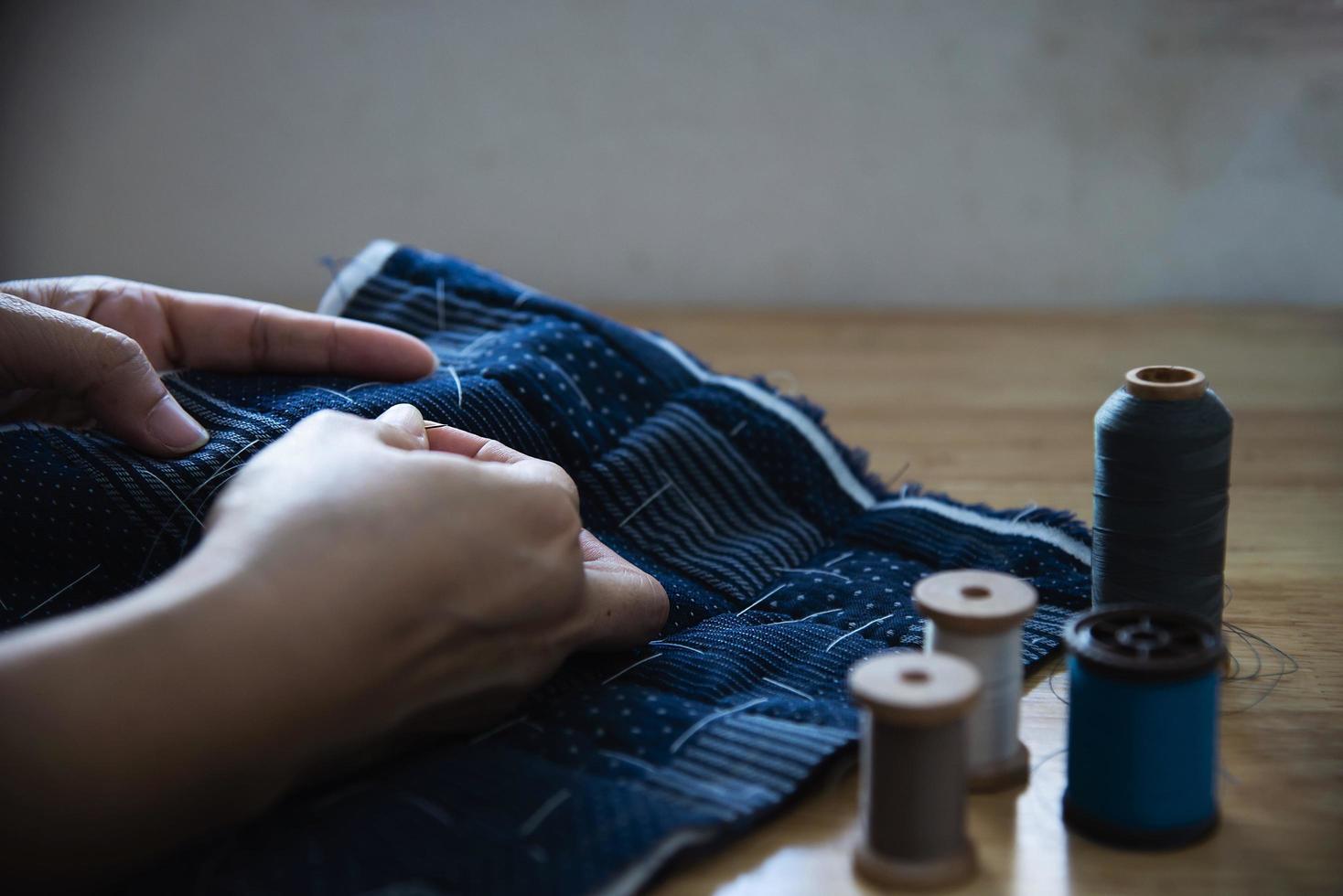 panno per cucire donna vintage a mano con ricamo impostato su sfondo tavolo in legno - persone e concetto di lavoro domestico fai da te fatto a mano foto