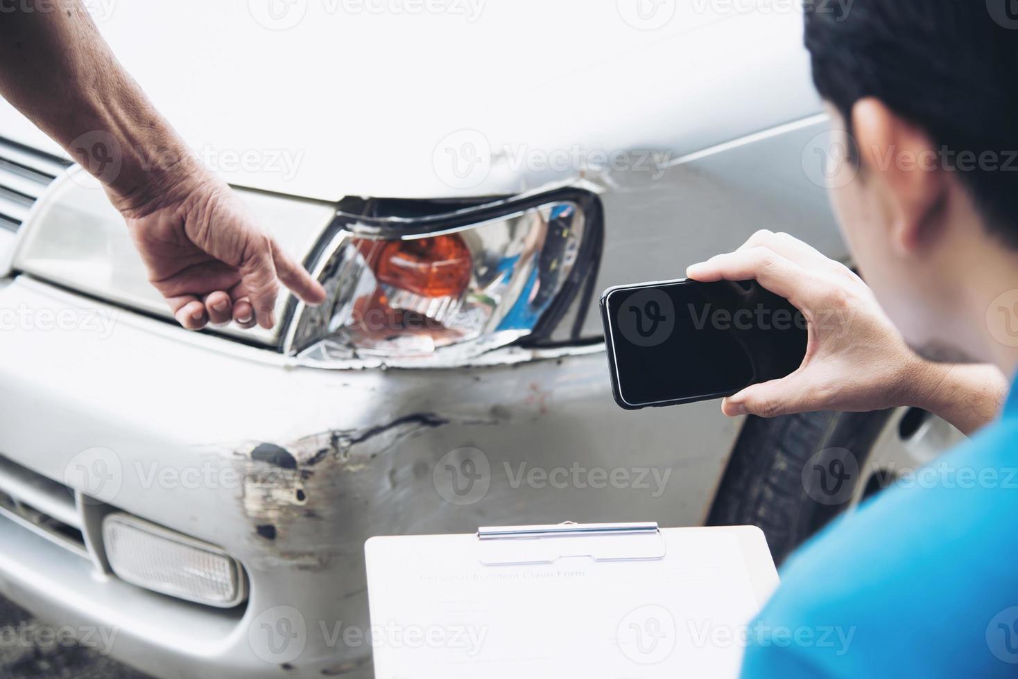 agente assicurativo che lavora durante il processo di richiesta di risarcimento per incidente stradale in loco - concetto di richiesta di risarcimento per le persone e l'assicurazione auto foto