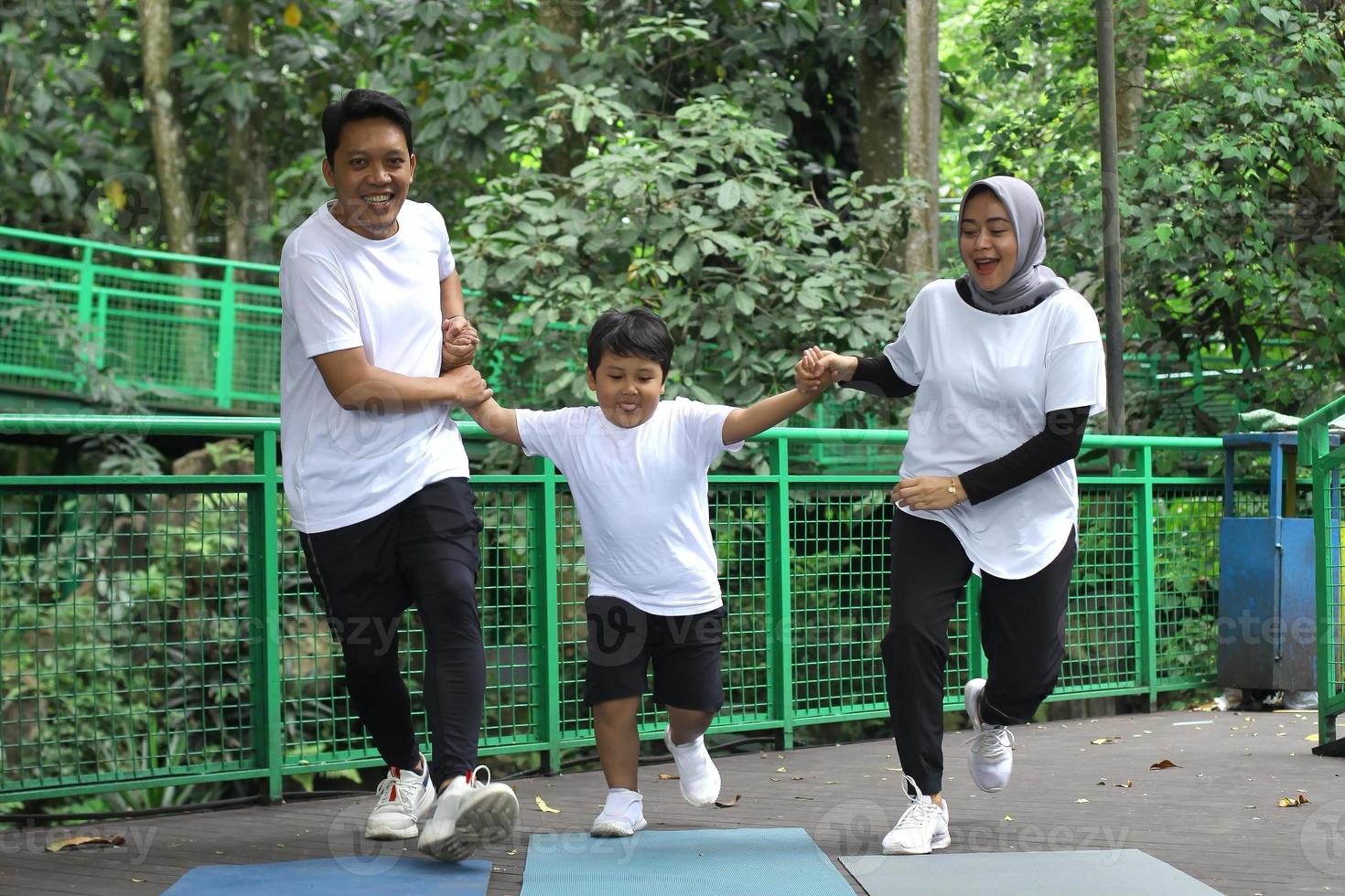 famiglia asiatica divertendosi esercitando lo sport insieme al parco. foto