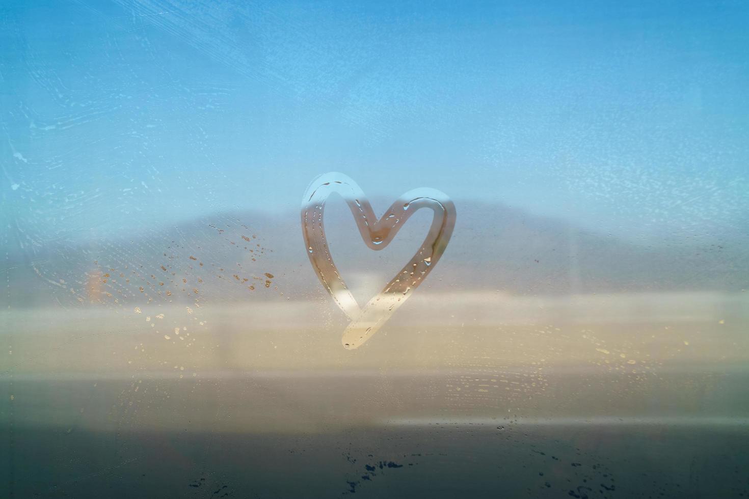 concetto di san valentino a forma di cuore disegnare a mano sullo specchio nebbioso foto