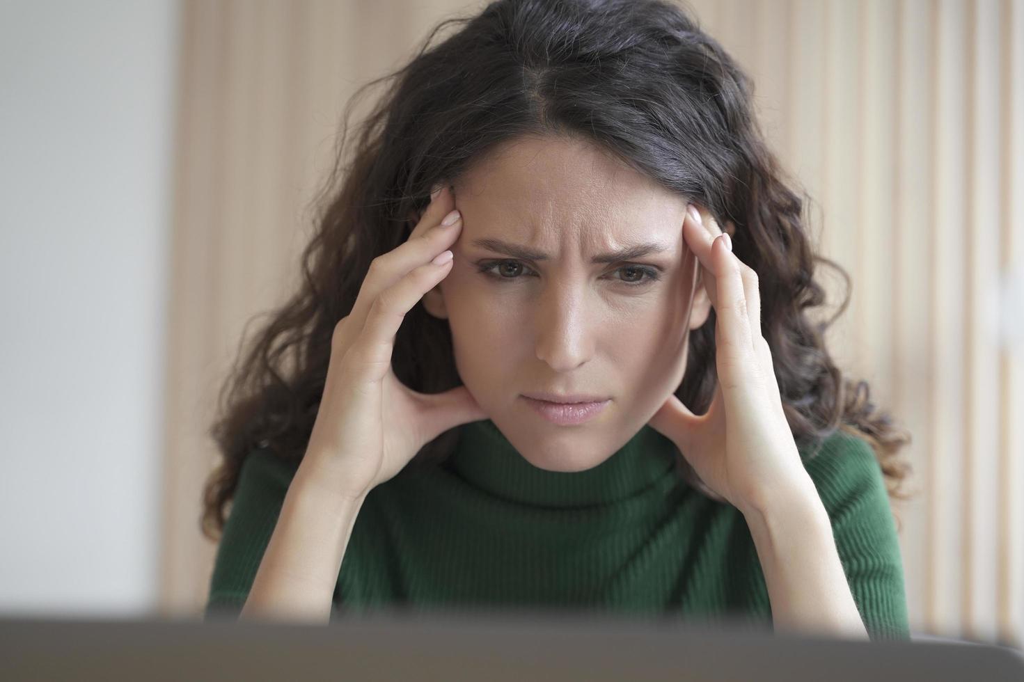 preoccupata giovane donna italiana dipendente che guarda lo schermo del computer con un'espressione del viso frustrata foto