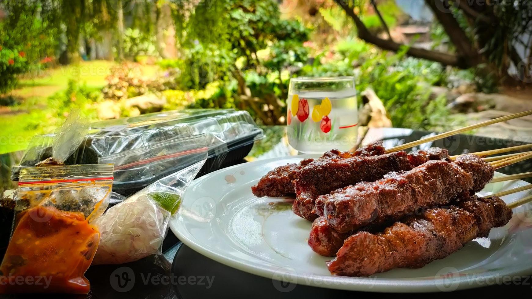 satay di maiale o sate babi servito con una fotografia di salsa di arachidi foto