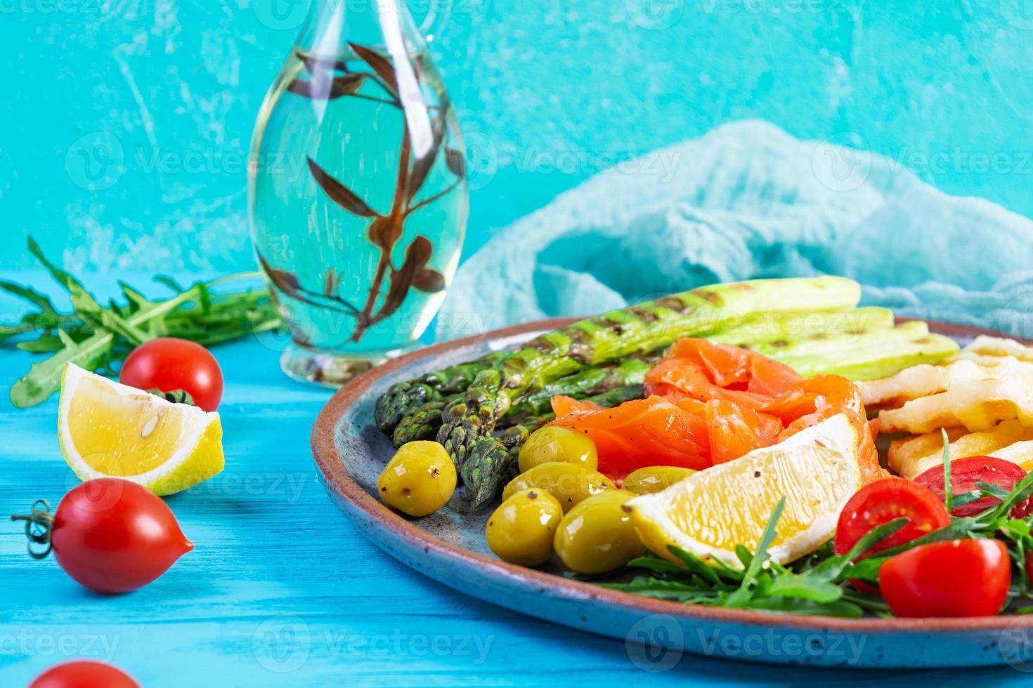 insalata con asparagi, halloumi grigliato, filetto di salmone, pomodori, rucola e olive verdi foto