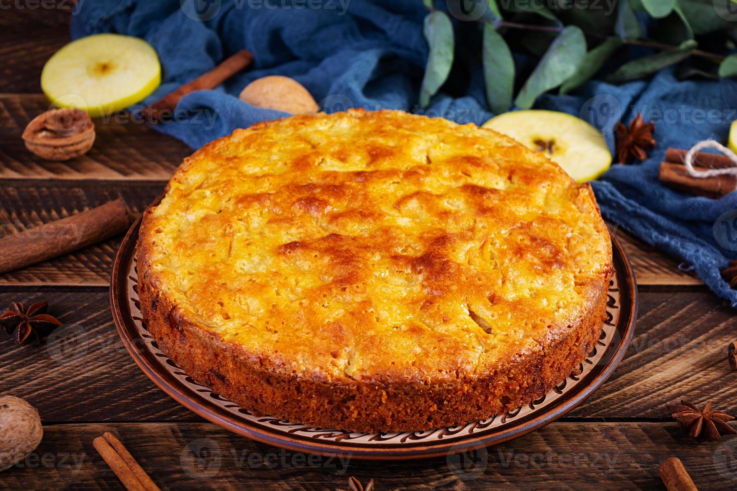 deliziosa torta di mele fatta in casa su fondo di legno. torta di mele con ingredienti, mele e cannella foto