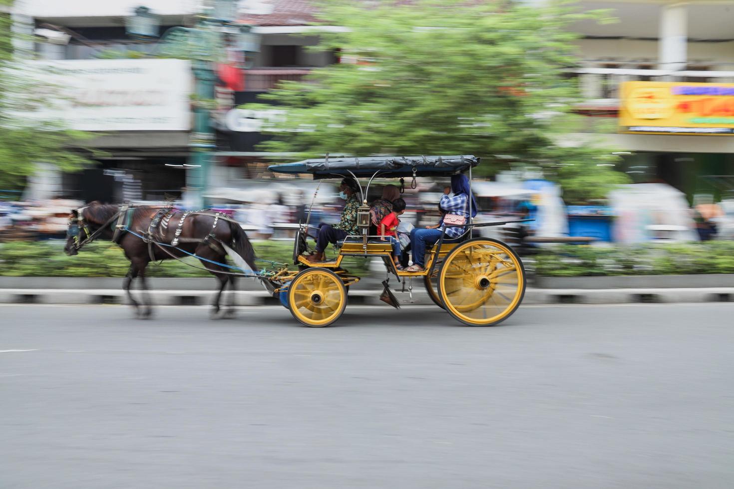 yogyakarta, indonesia - maggio 2022 ritratto in movimento sfocato di un turista che guida un delman a jalan malioboro. delman è un veicolo tradizionale di java, indonesia. foto