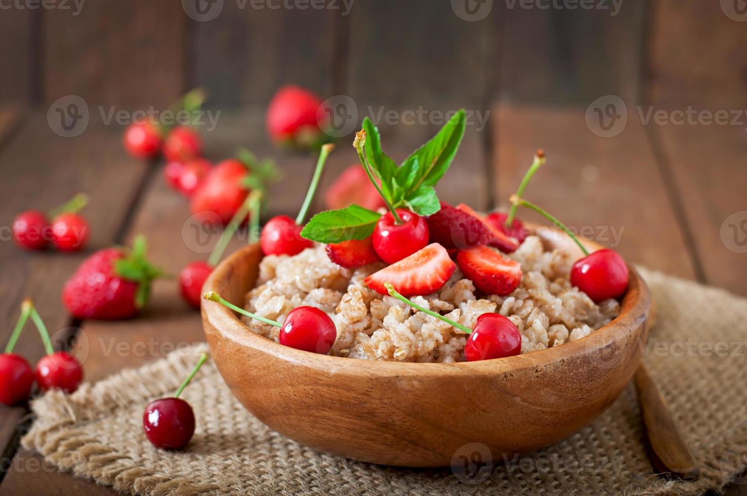 porridge di farina d'avena con frutti di bosco in una ciotola bianca foto